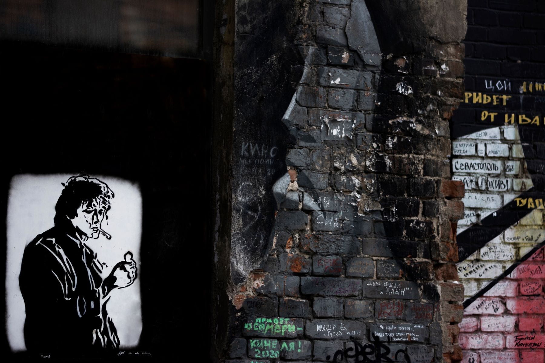 Layered murals and graffiti on a brick wall in Sofia