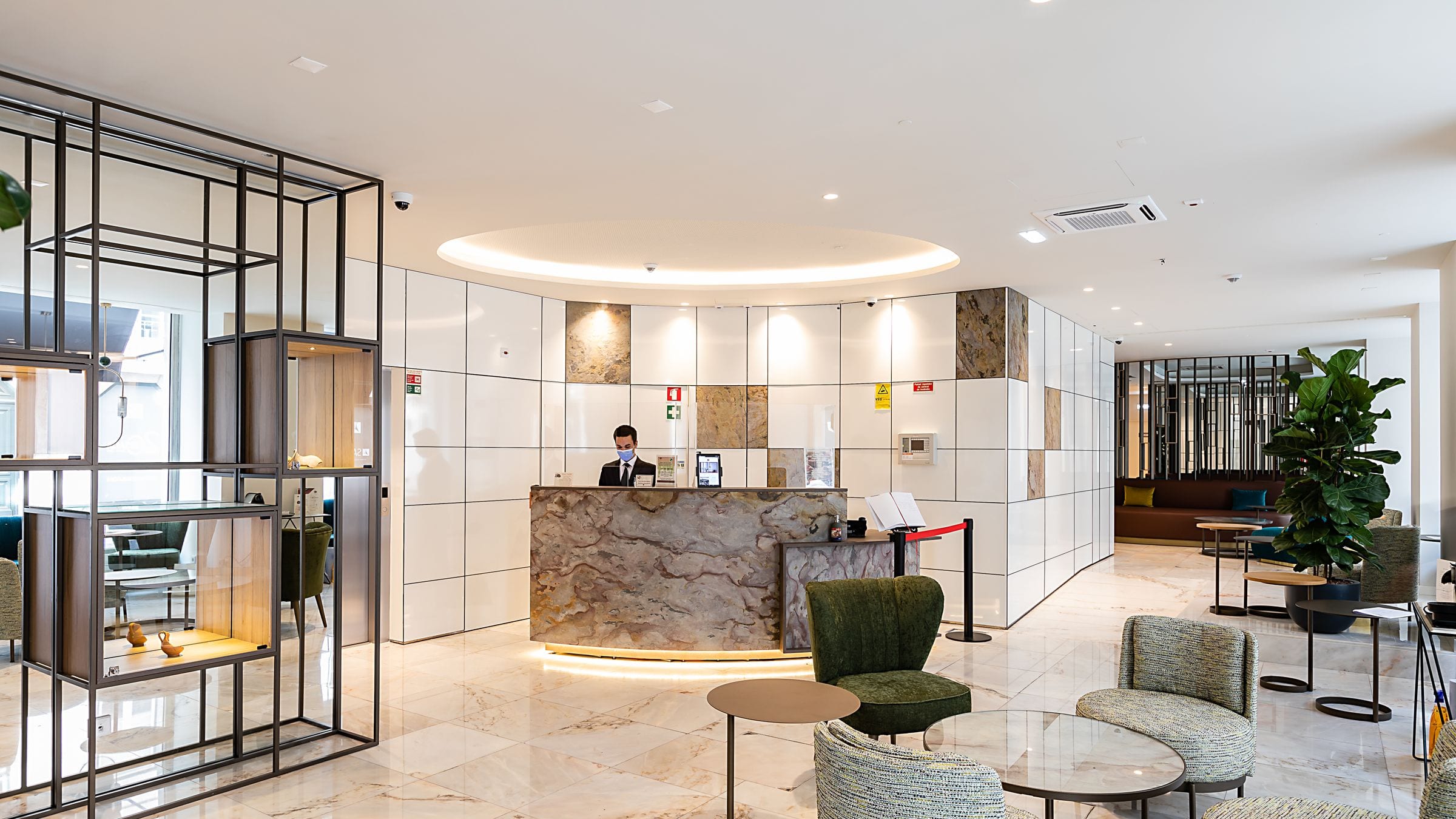 A bright, elegant five-star hotel lobby with a marble reception desk and plenty of open space, lit by warm natural sunlight.